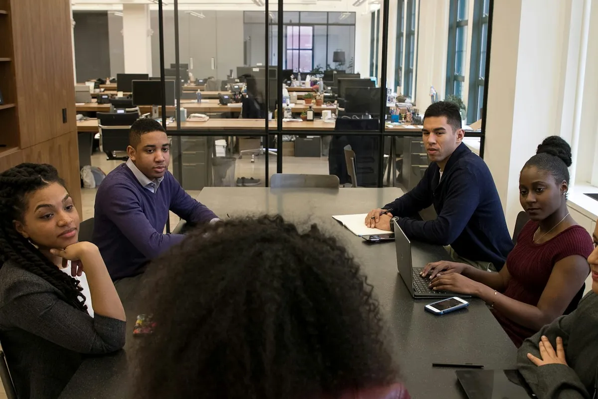 Students listening to each other around a seminar table